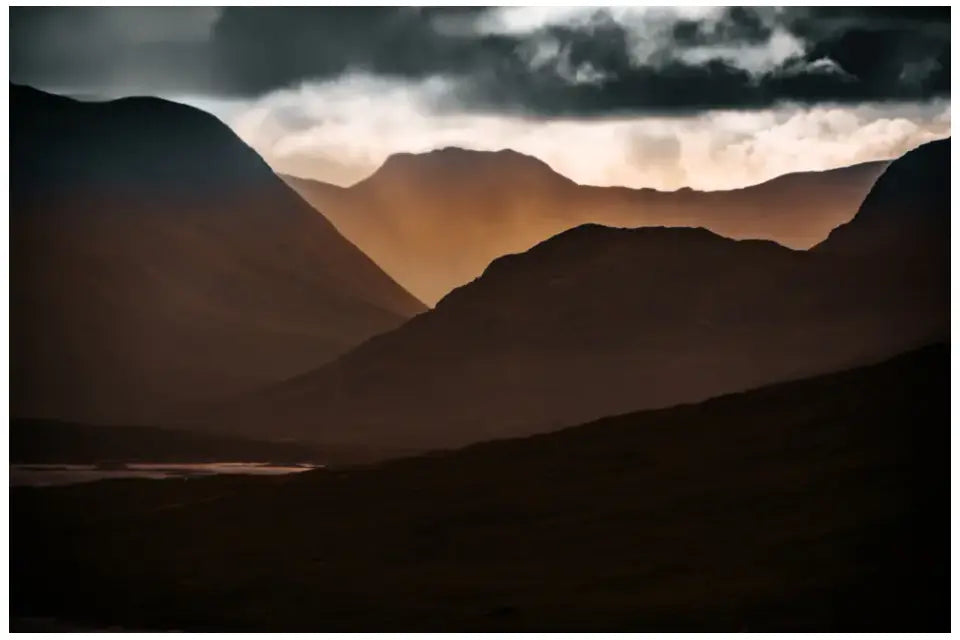 Highlands Schottland Wandbild: Dramatischer Sonnenuntergang über den Berggipfeln